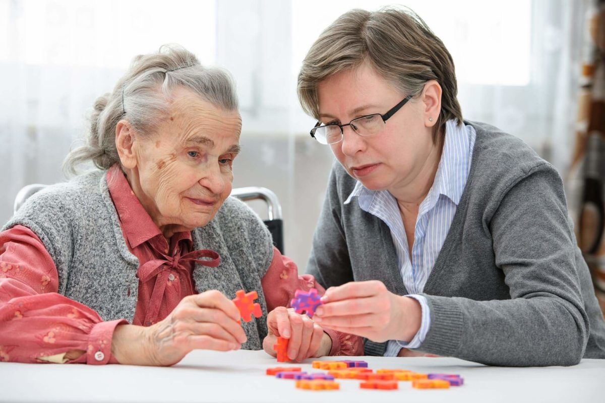 Senior woman compelting a puzzel at The Hamptons at Meadows Place