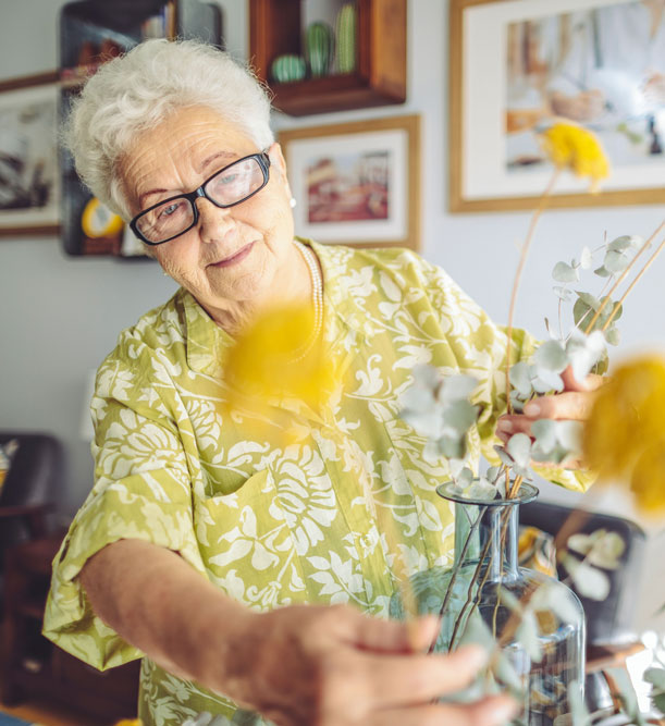 older adult with flowers | The Hampton at Meadows Place older adult with flowers