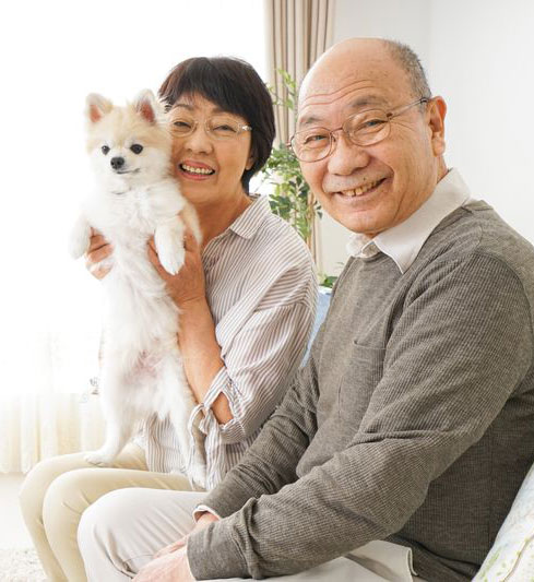 older Asian adults holding a dog