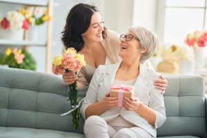 Adult daughter surprising her mom with flowers