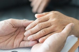 Woman holding a senior's hand