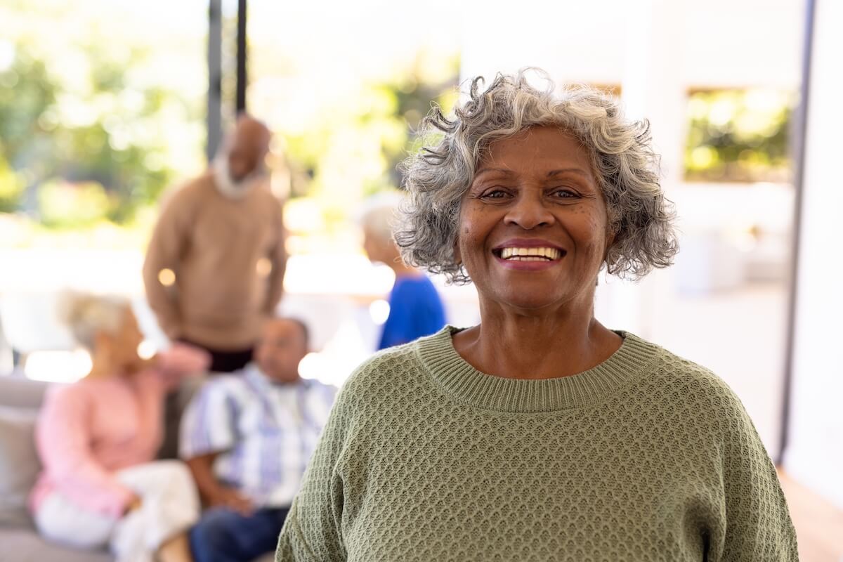 smiling black woman | The Hampton at Meadows Place Smiling older woman with her elderly friends in the background