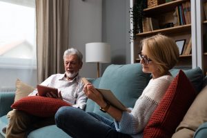 A couple of older adults reading in a senior living library