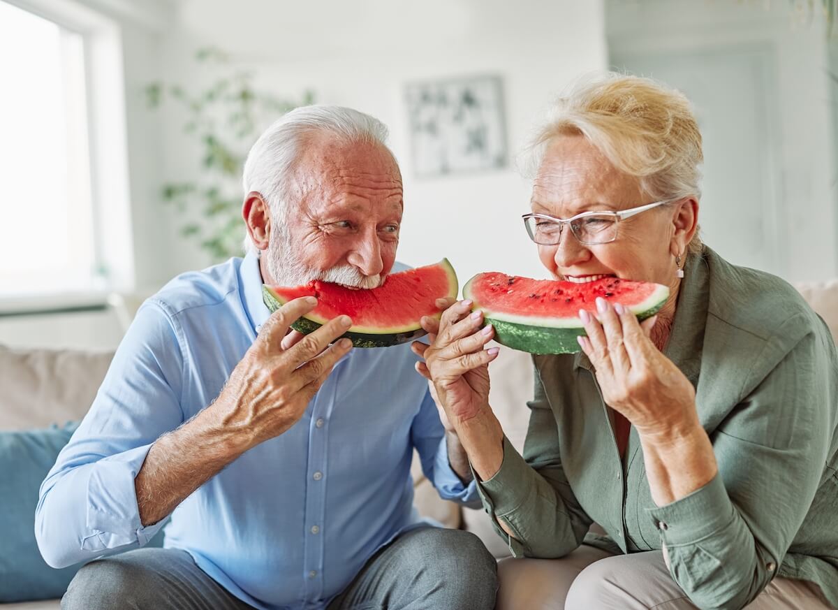 seniors eating watermelon | The Hampton at Meadows Place A couple of older adults eating a watermelon in a senior living community