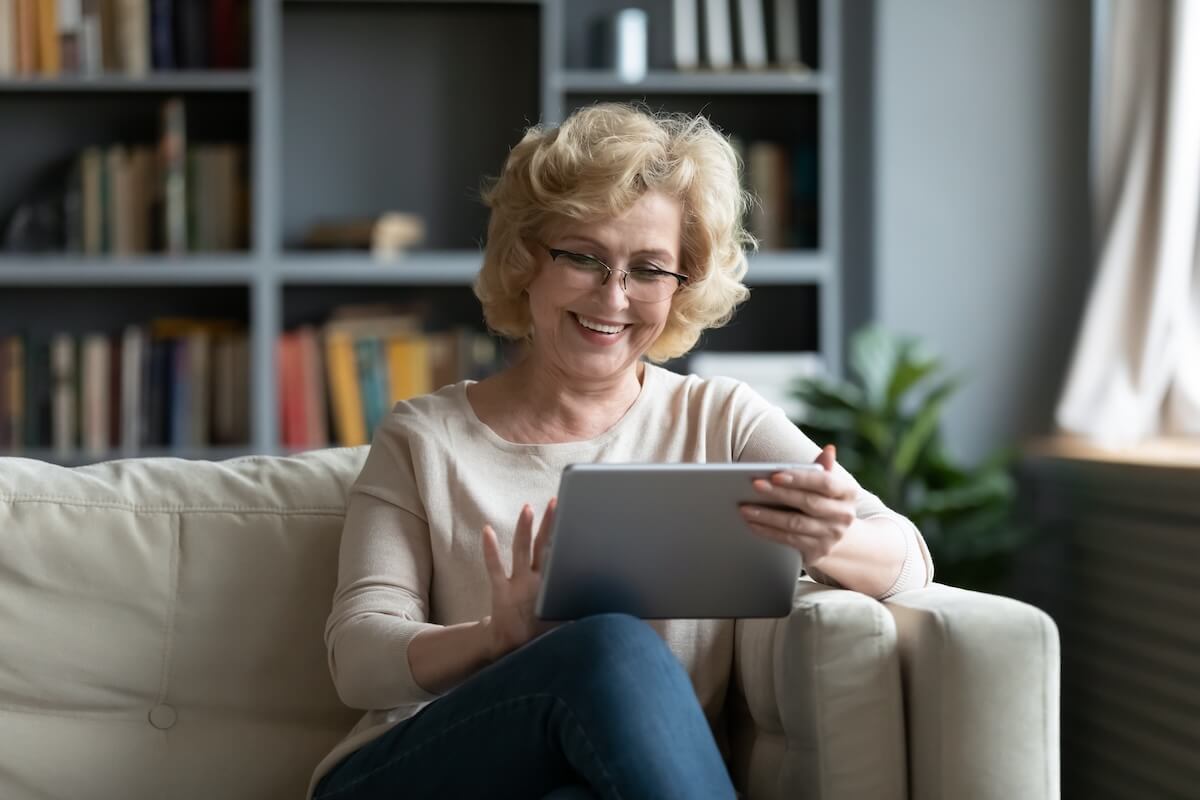 shutterstock_1660204060 | The Hampton at Meadows Place Older woman happily using a tablet