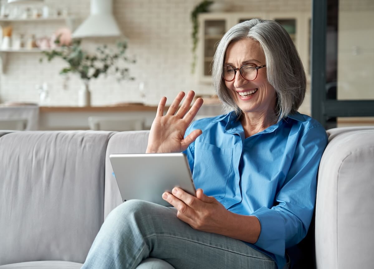 shutterstock_1818491885 | The Hampton at Meadows Place Older woman waving to a tablet
