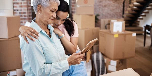 Old Adult and adult child unpacking and looking at ipad